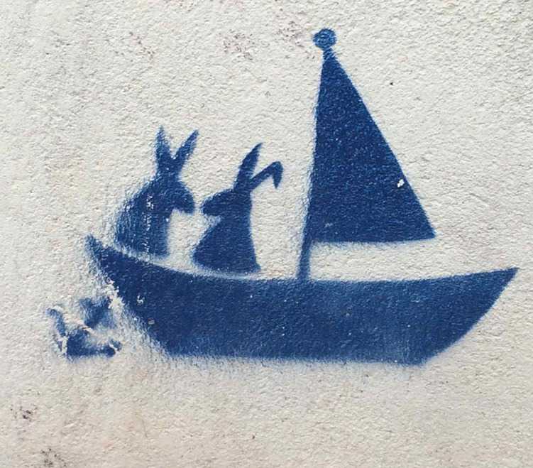 blaues Graffiti von zwei Hasen in einem Segelboot