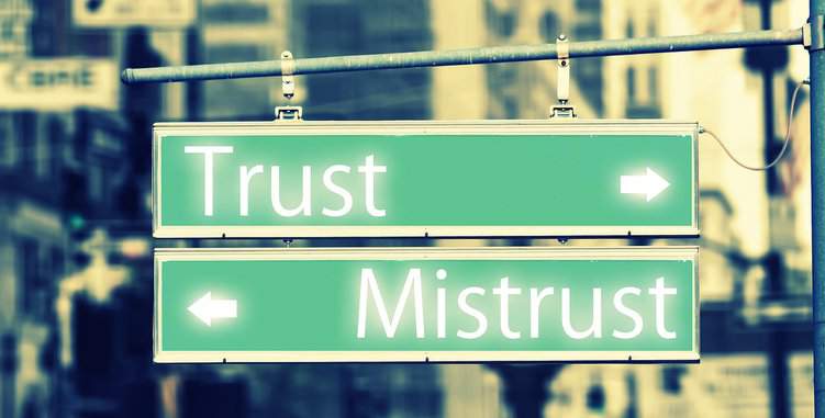 zwei Schilder, die in zwei verschiedene Richtungen zeigen, auf denen steht "trust" und "misstrust"